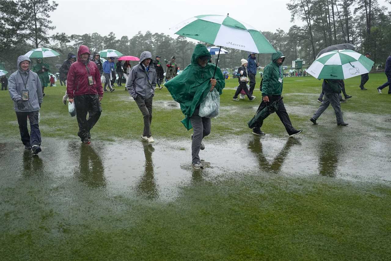 Patrons leave the course after play was suspended for the day in the weather delayed third round of the Masters golf tournament at Augusta National Golf Club on Saturday, April 8, 2023, in Augusta, Ga. (AP Photo/David J. Phillip)