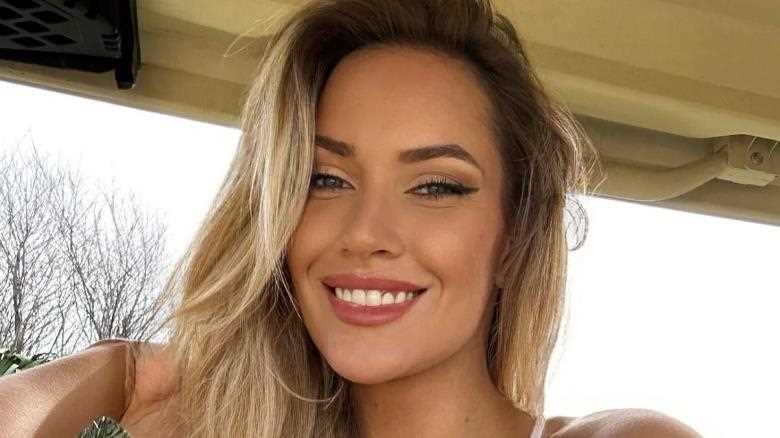 Paige Spiranac spills from tiny vest top while driving golf buggy, as fans exclaim 'breathtakingly gorgeous smile'