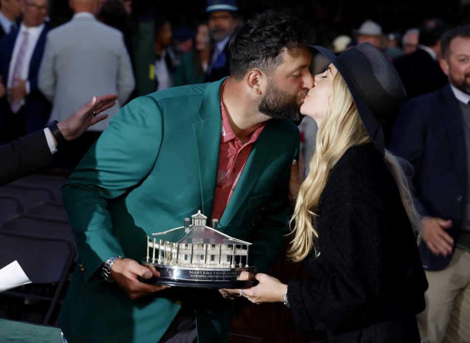 Golf - The Masters - Augusta National Golf Club - Augusta, Georgia, U.S. - April 9, 2023 Spain's Jon Rahm celebrates with wife Kelley as he is presented with his green jacket and the trophy after winning The Masters REUTERS/Jonathan Ernst