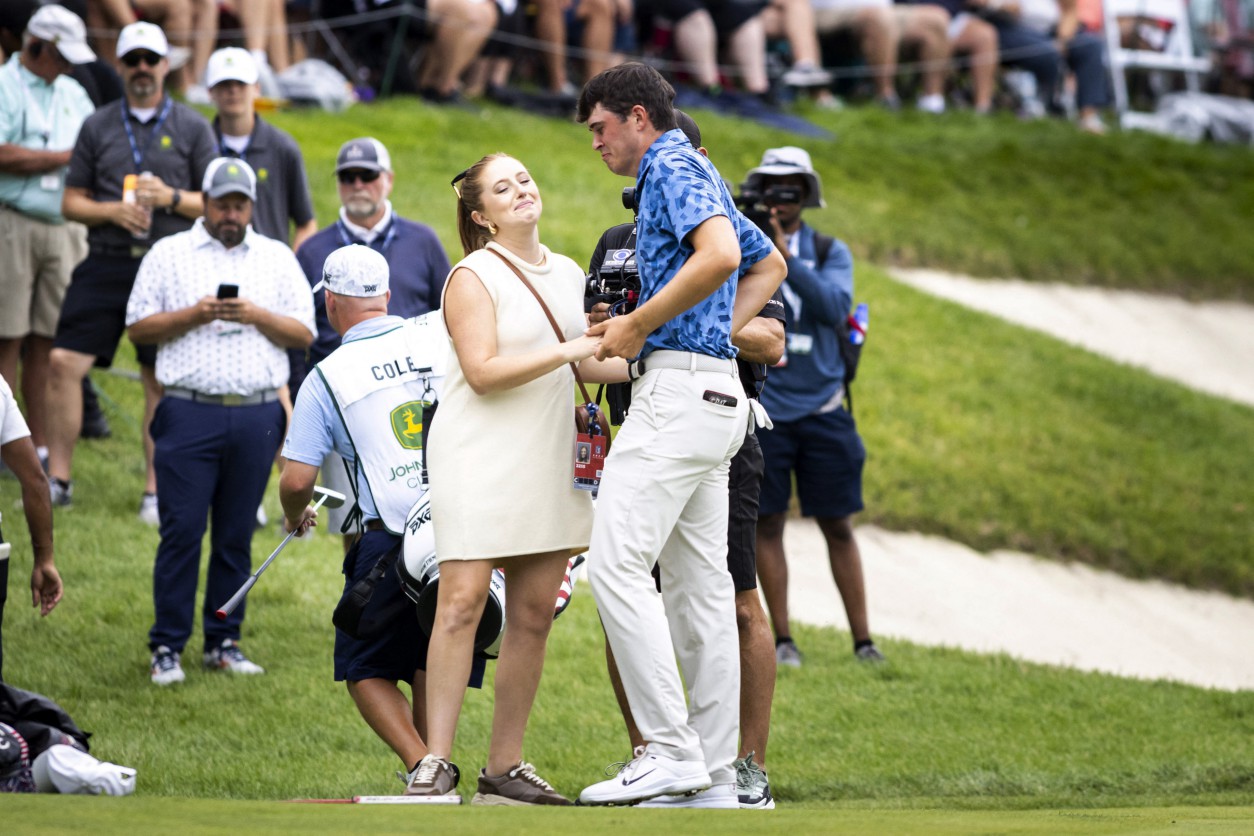 Jul 7, 2024; Silvis, Illinois, USA; Davis Thompson (right) embraces his wife Holly Grace Robinson Thompson on 18th green during the final round of the John Deere Classic golf tournament. Mandatory Credit: Joseph Cress-USA TODAY Sports