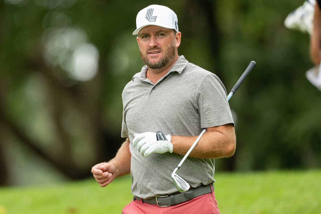 a golfer wearing a white hat with the letter l on it