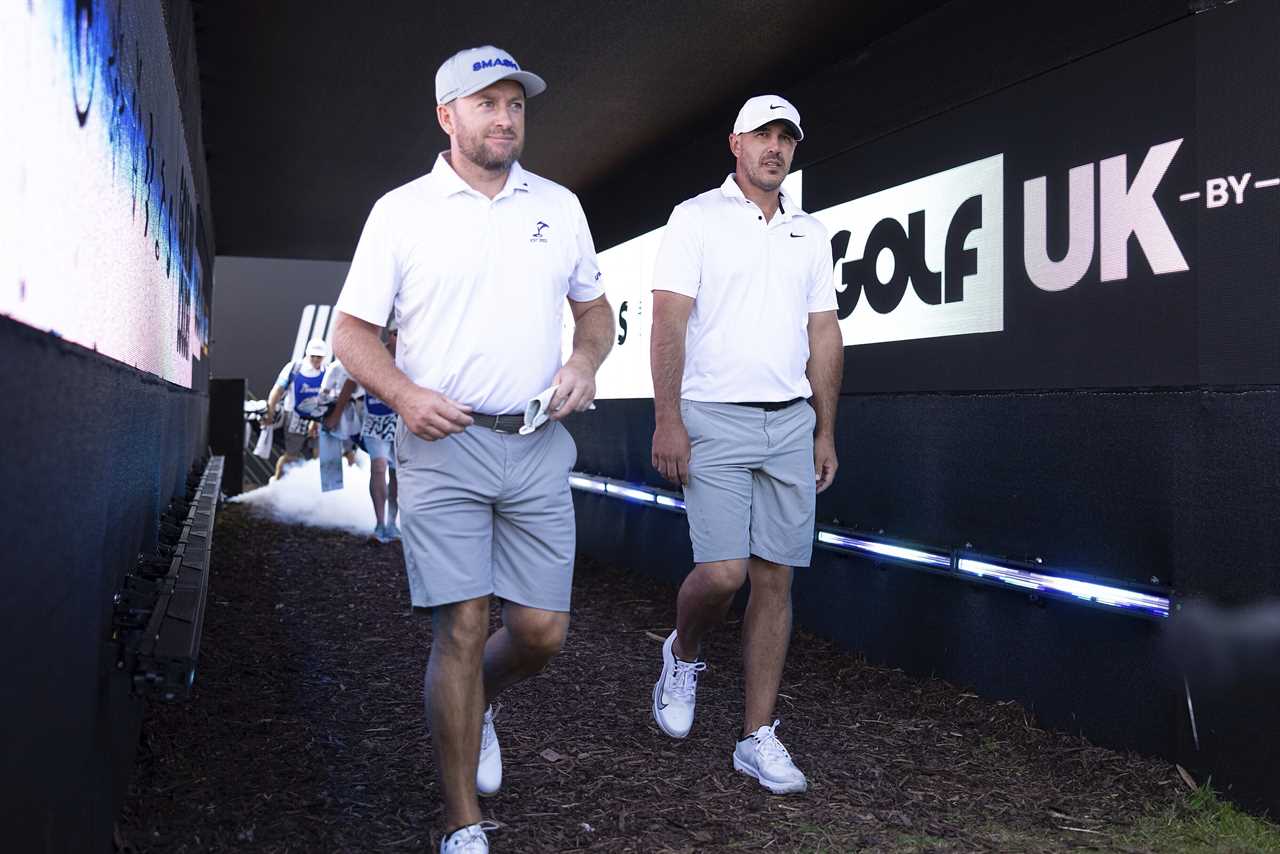 two men walk through a tunnel that says golf uk