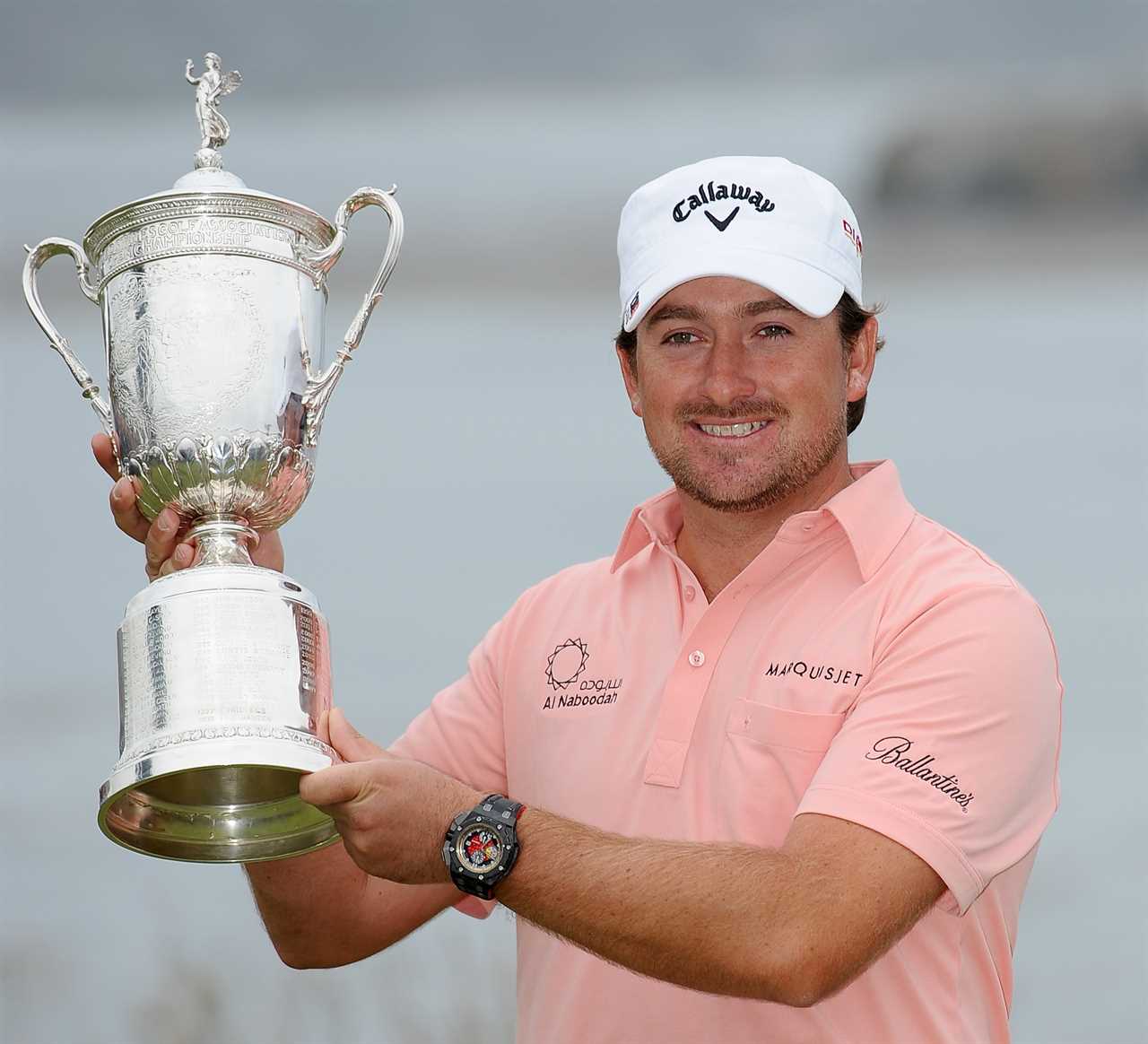 a man holding a trophy that says ballantine on his shirt