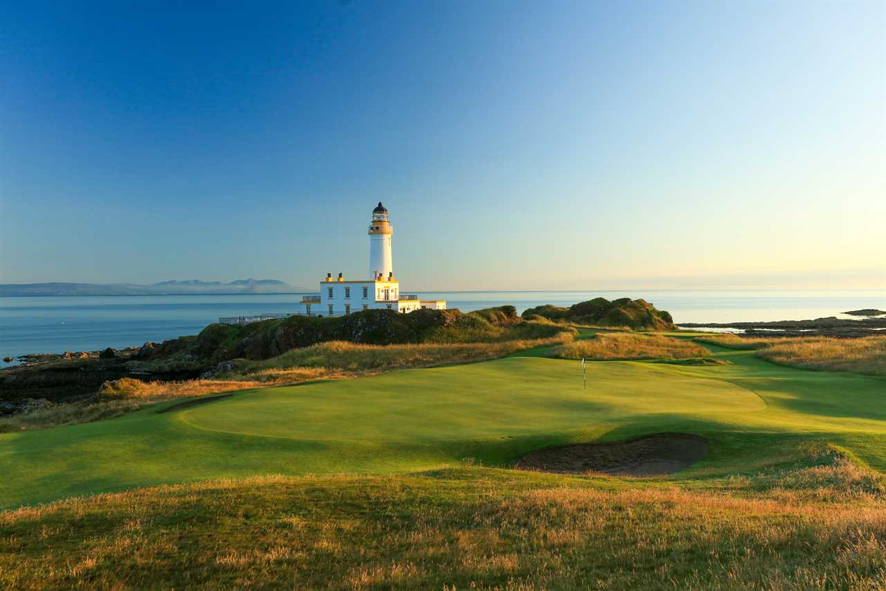 a golf course with a lighthouse in the background