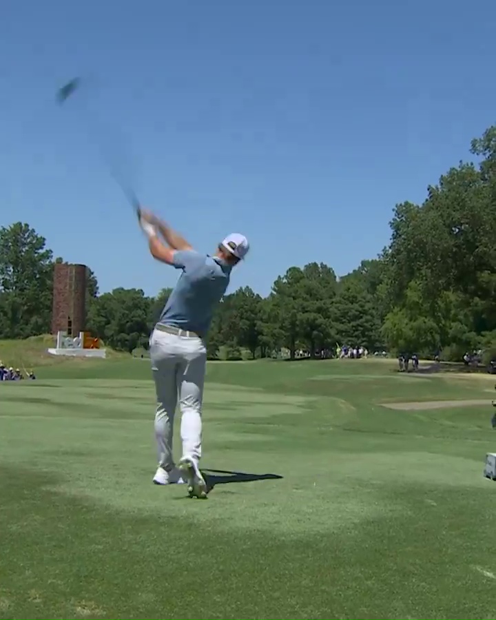 a man swings a golf club on a golf course