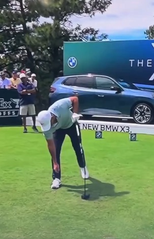 a man is swinging a golf club on a golf course with a new bmw x3 in the background