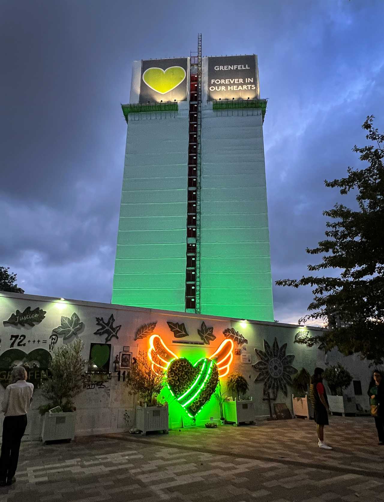 a green building with a sign that says grenfell forever in our hearts