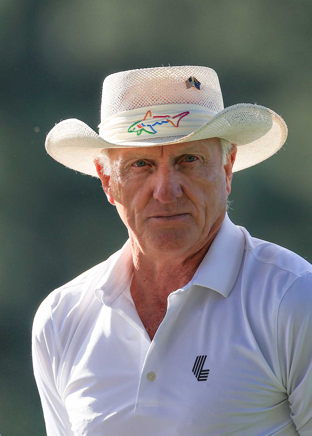 a man wearing a cowboy hat and a white polo shirt