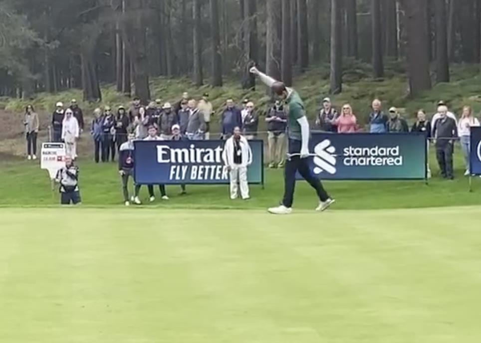 a man playing golf in front of an emirates fly better banner