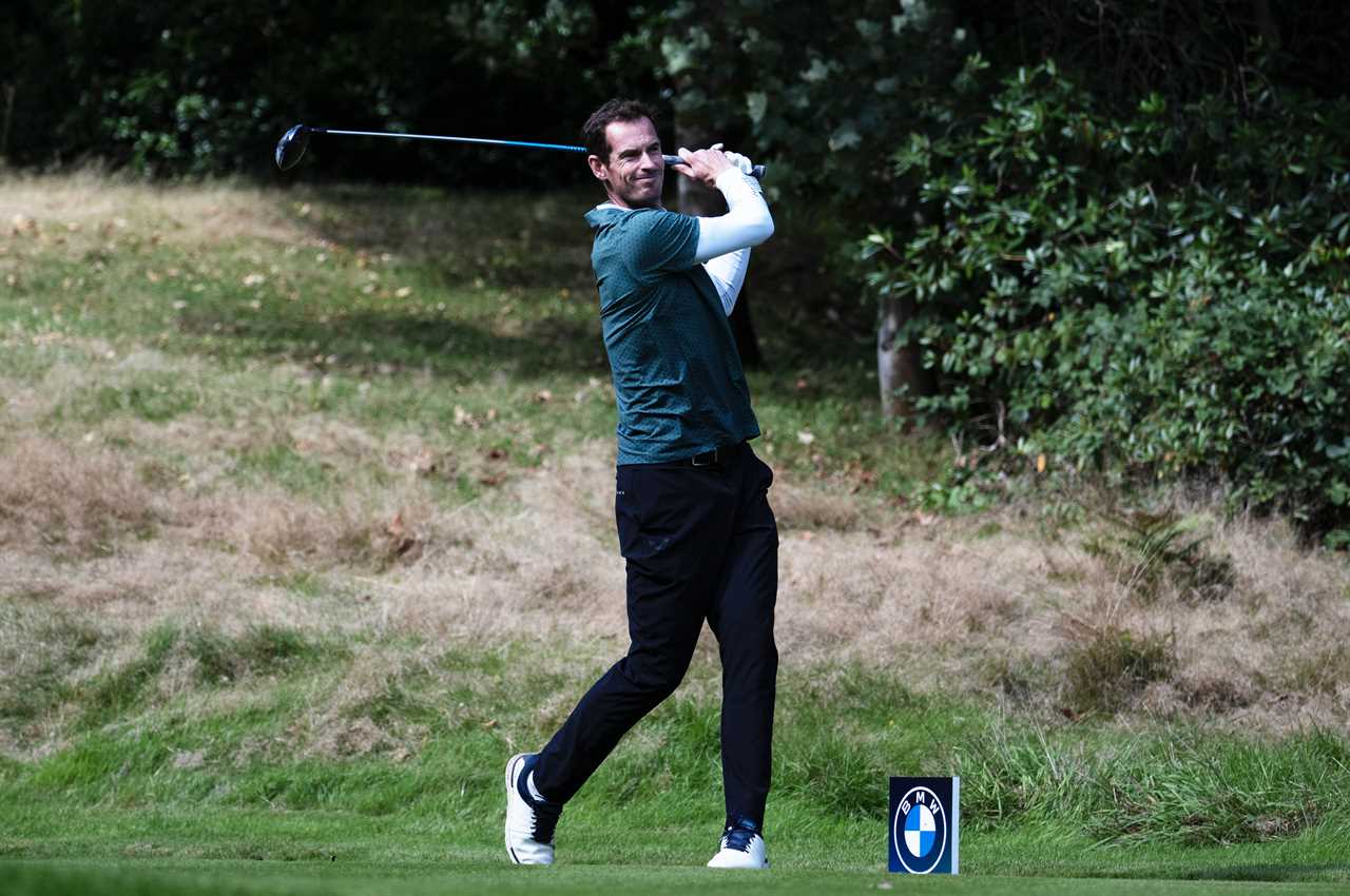 a man swings a golf club in front of a bmw sign