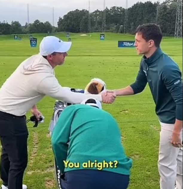 a man is shaking hands with another man on a golf course .