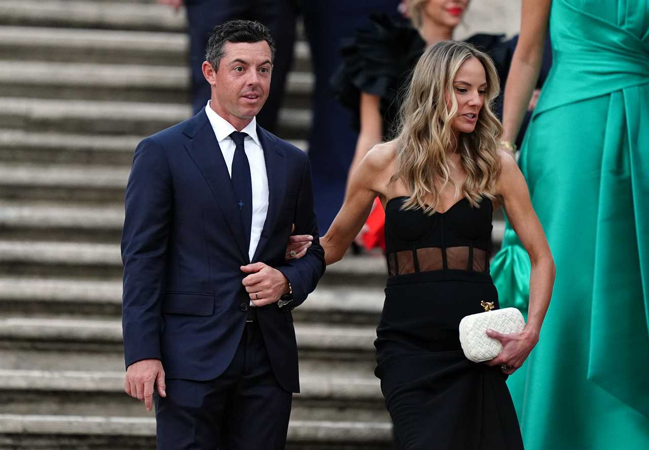 a man in a suit and tie stands next to a woman in a black dress