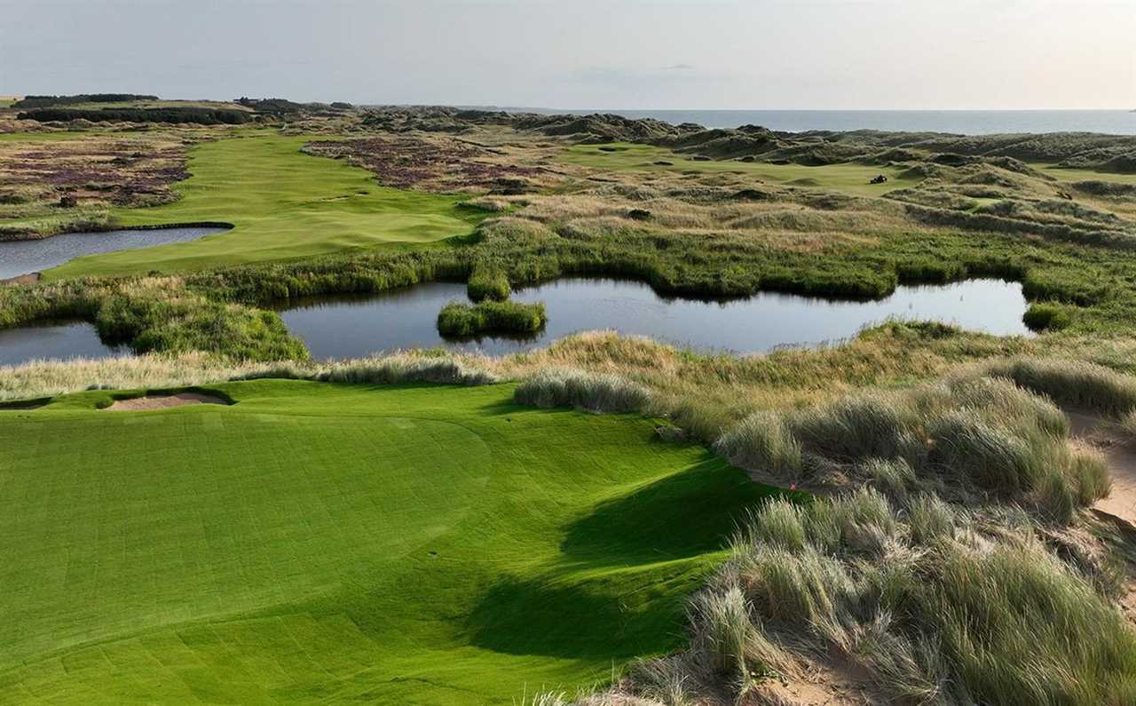 a golf course with a pond in the middle of it