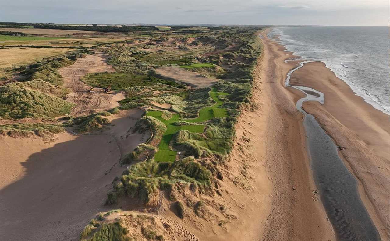 an aerial view of a sandy beach with a river running through it