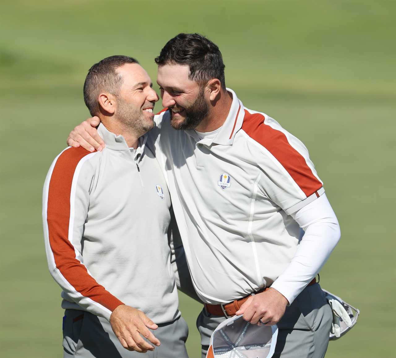 two men are hugging each other on a golf course