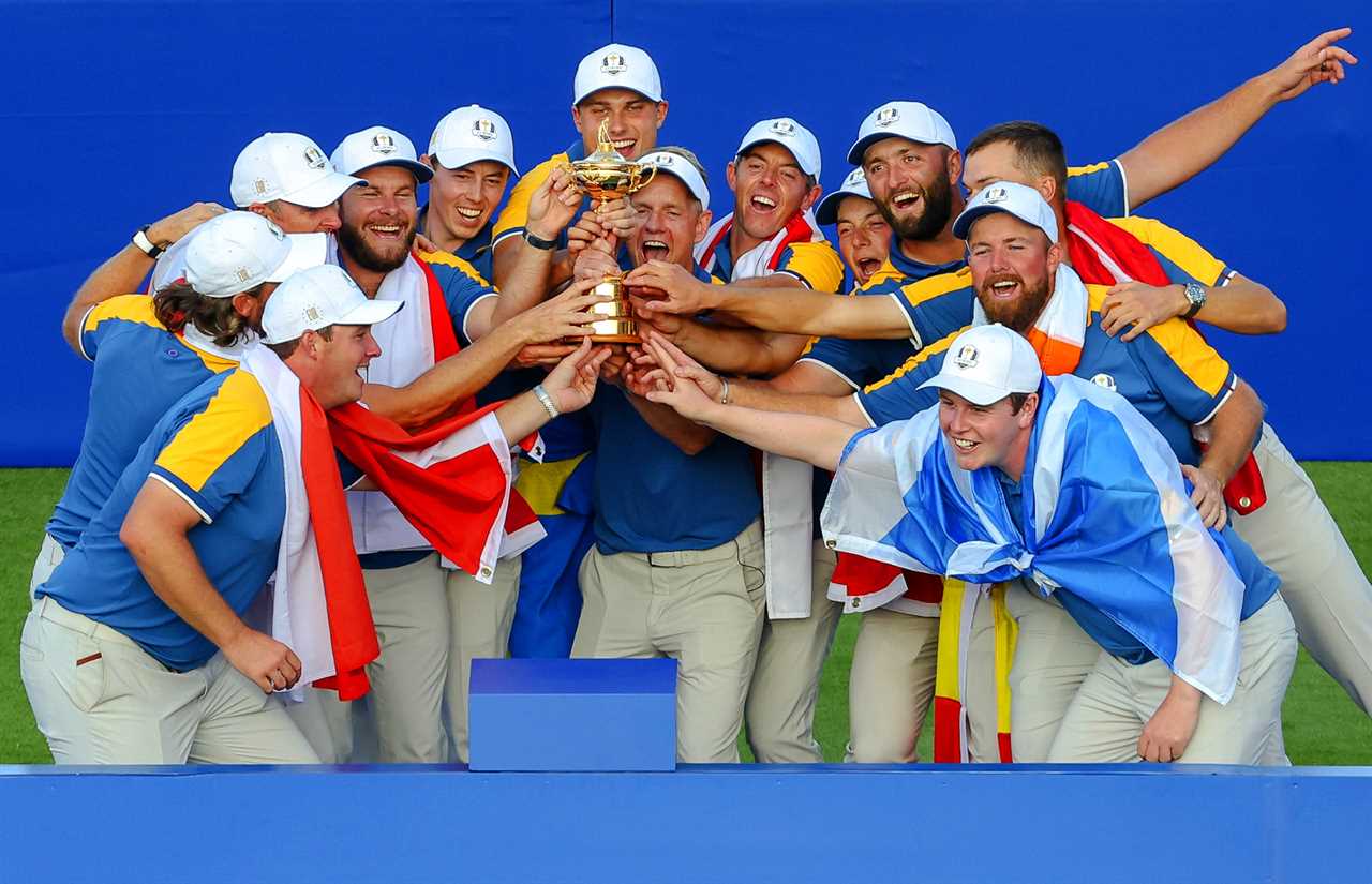 a group of men holding a trophy with the letter u on their hats