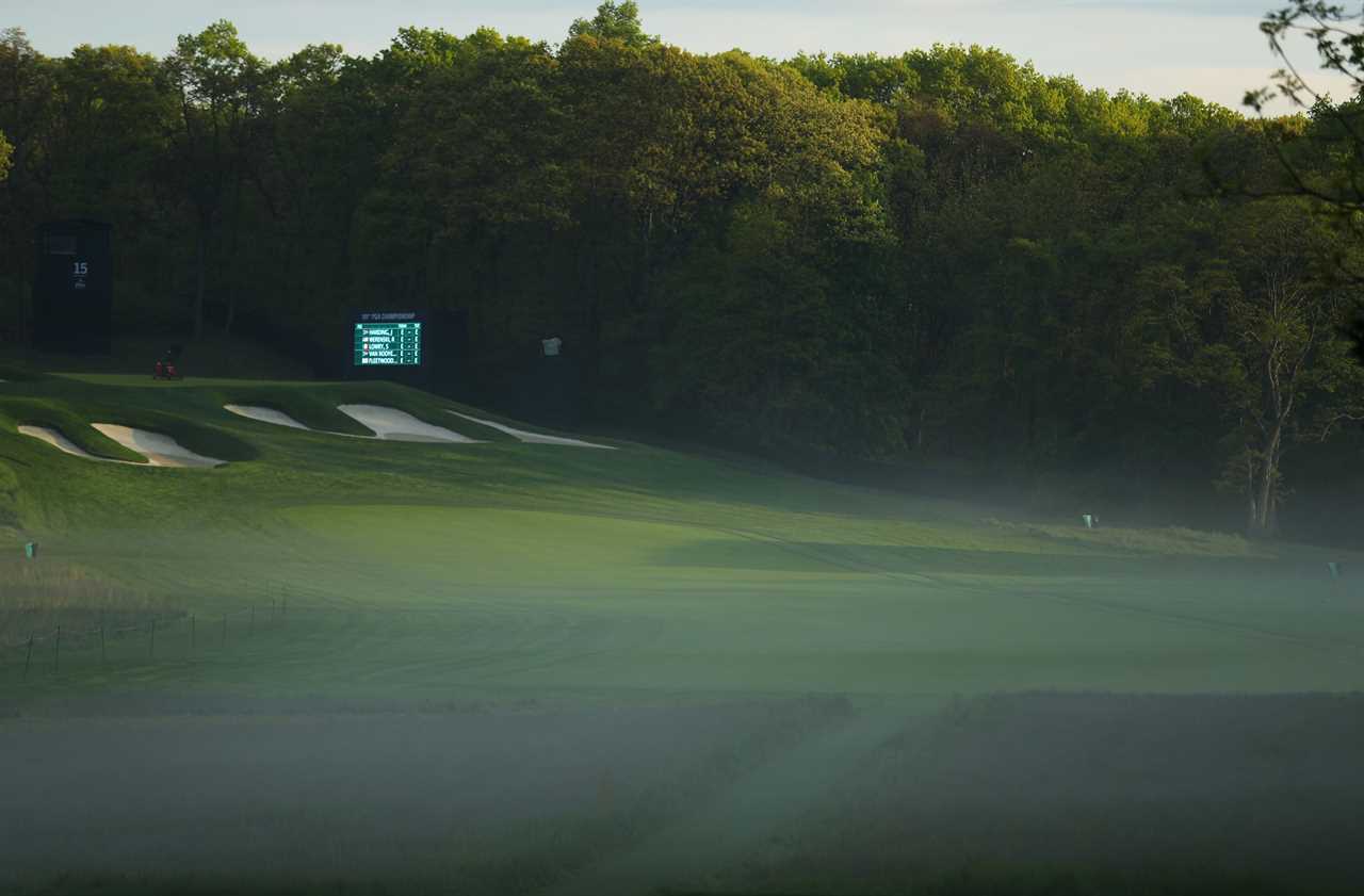 a foggy golf course with a scoreboard in the background