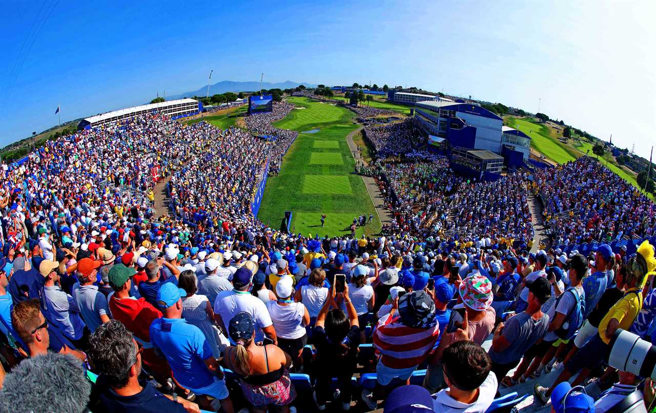 a large crowd of people watching a golf course with a sign that says ' rolex ' on it