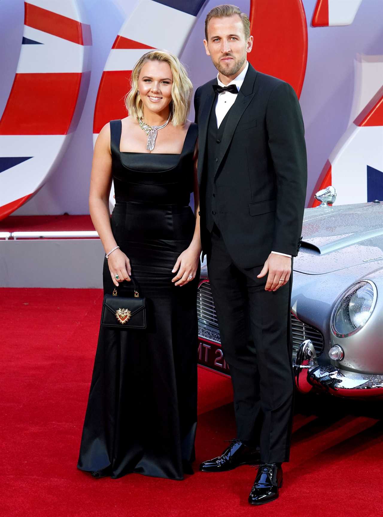 a man and woman standing next to each other on a red carpet