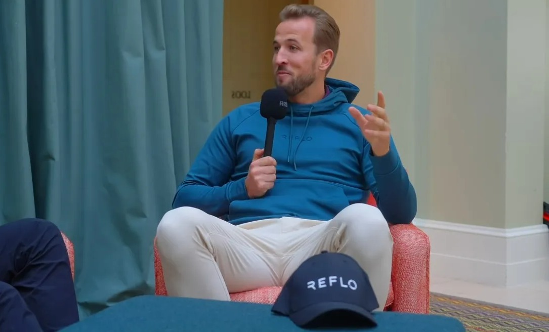 a man sitting in a chair with a microphone and a hat that says refle