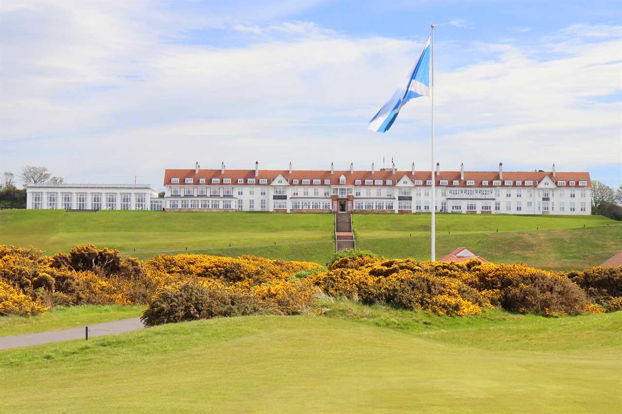 a flag is flying in front of a large white building