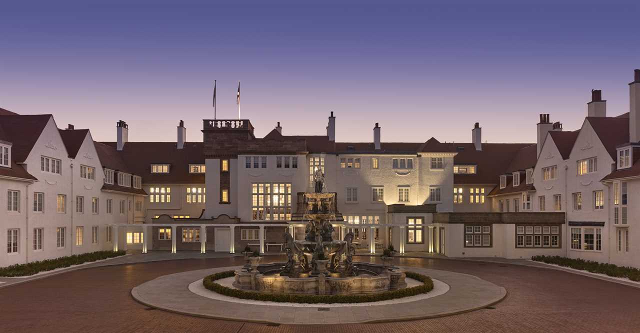 a large white building with a fountain in front of it