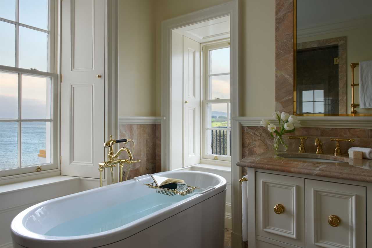 a bathtub in a bathroom with a view of the ocean