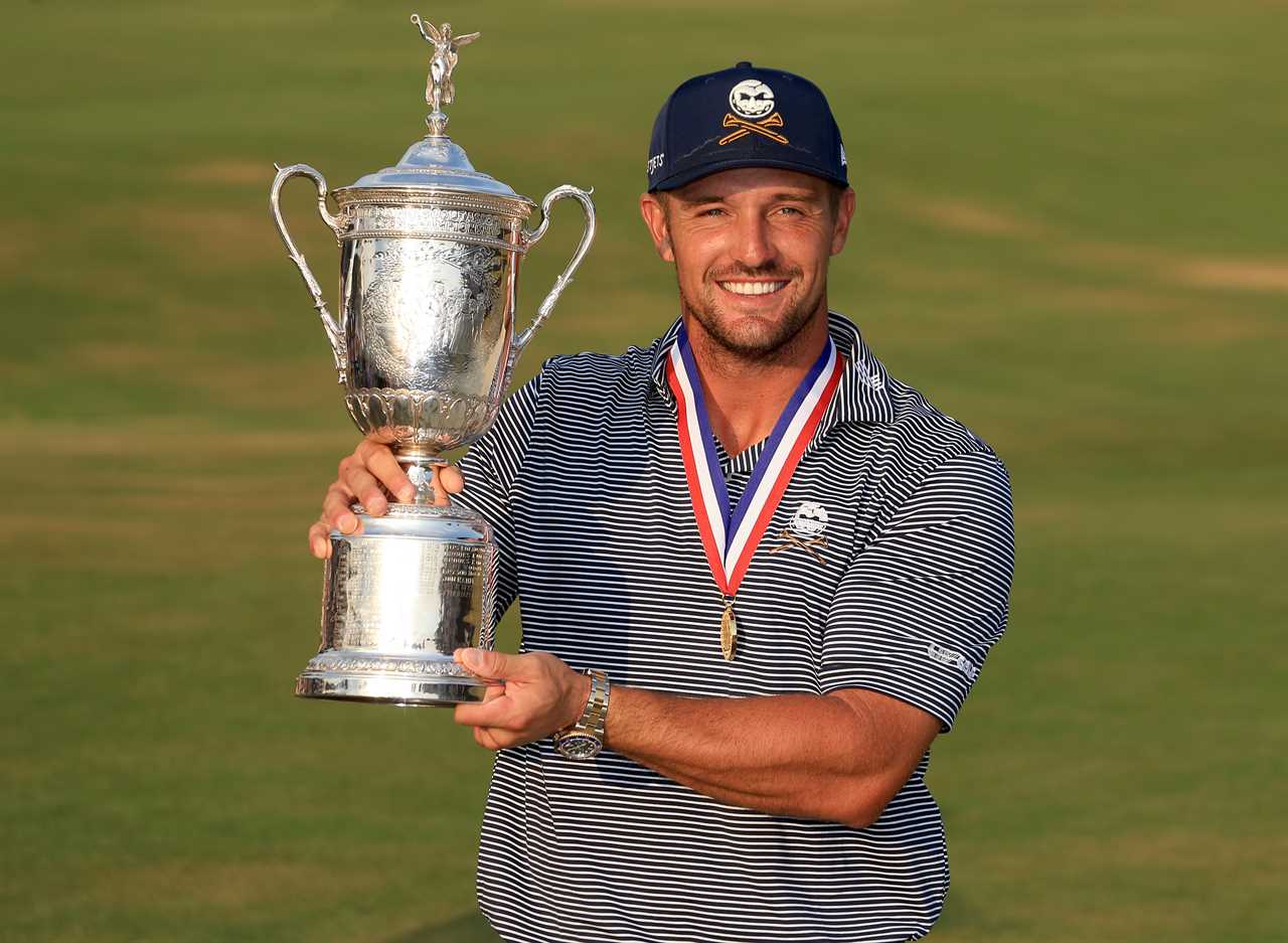 a man holding a trophy with a medal around his neck