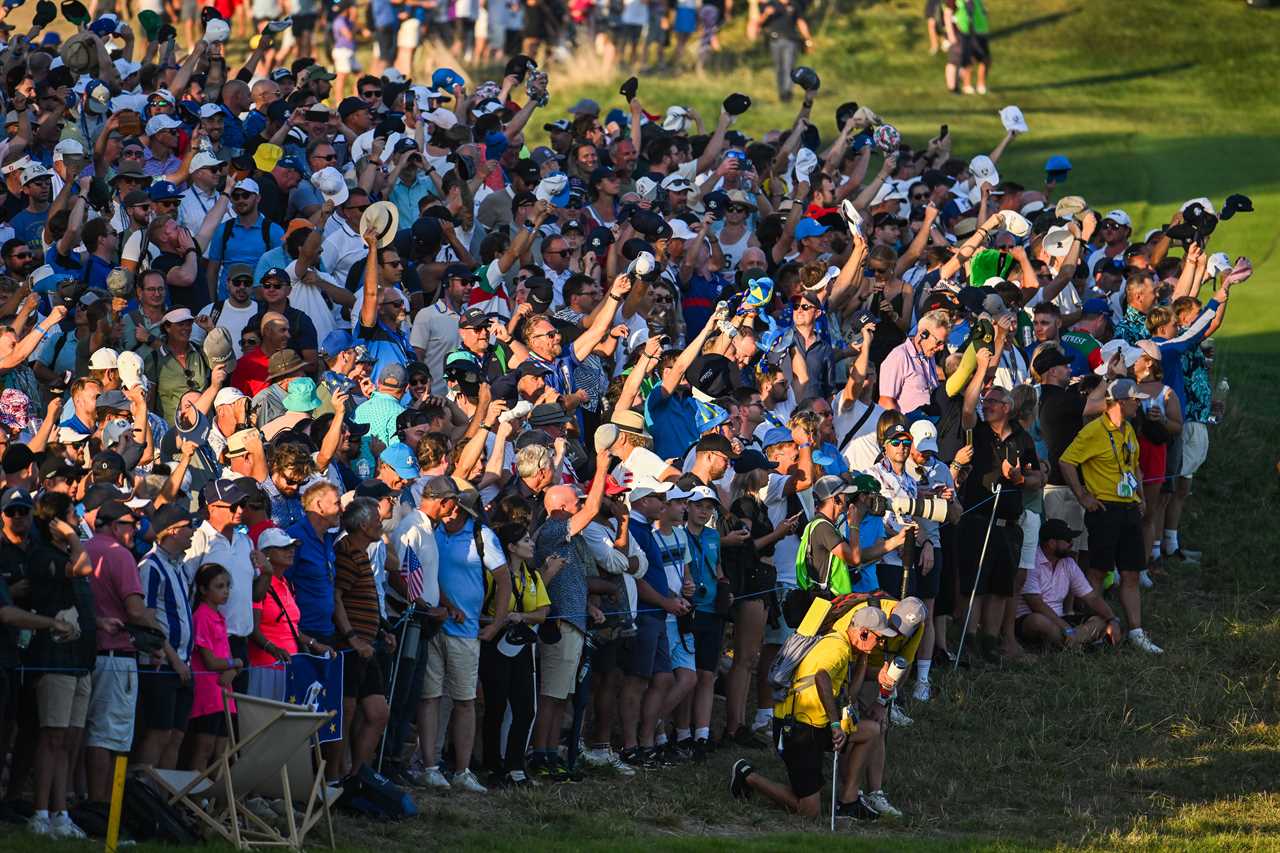 a crowd of people watching a golf game with one man wearing a yellow shirt that says ' us open ' on it