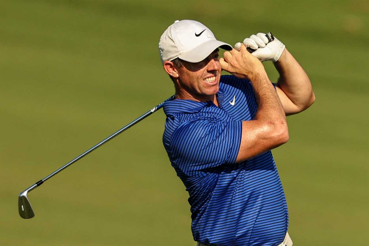 a man wearing a nike hat is swinging a golf club