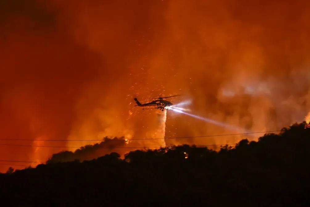 Helicopter fighting wildfire at night.