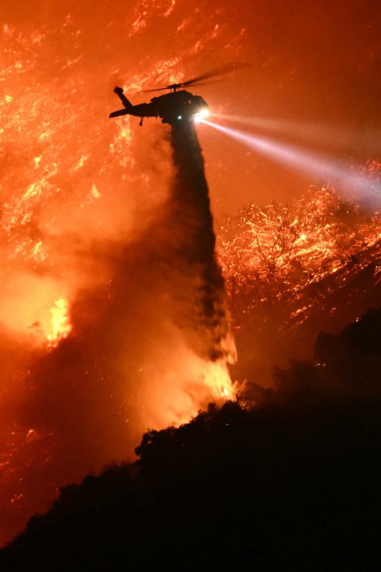 Helicopter dropping water on wildfire.