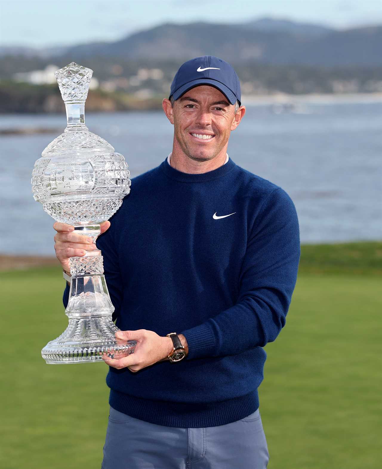 Rory McIlroy holding a crystal trophy.