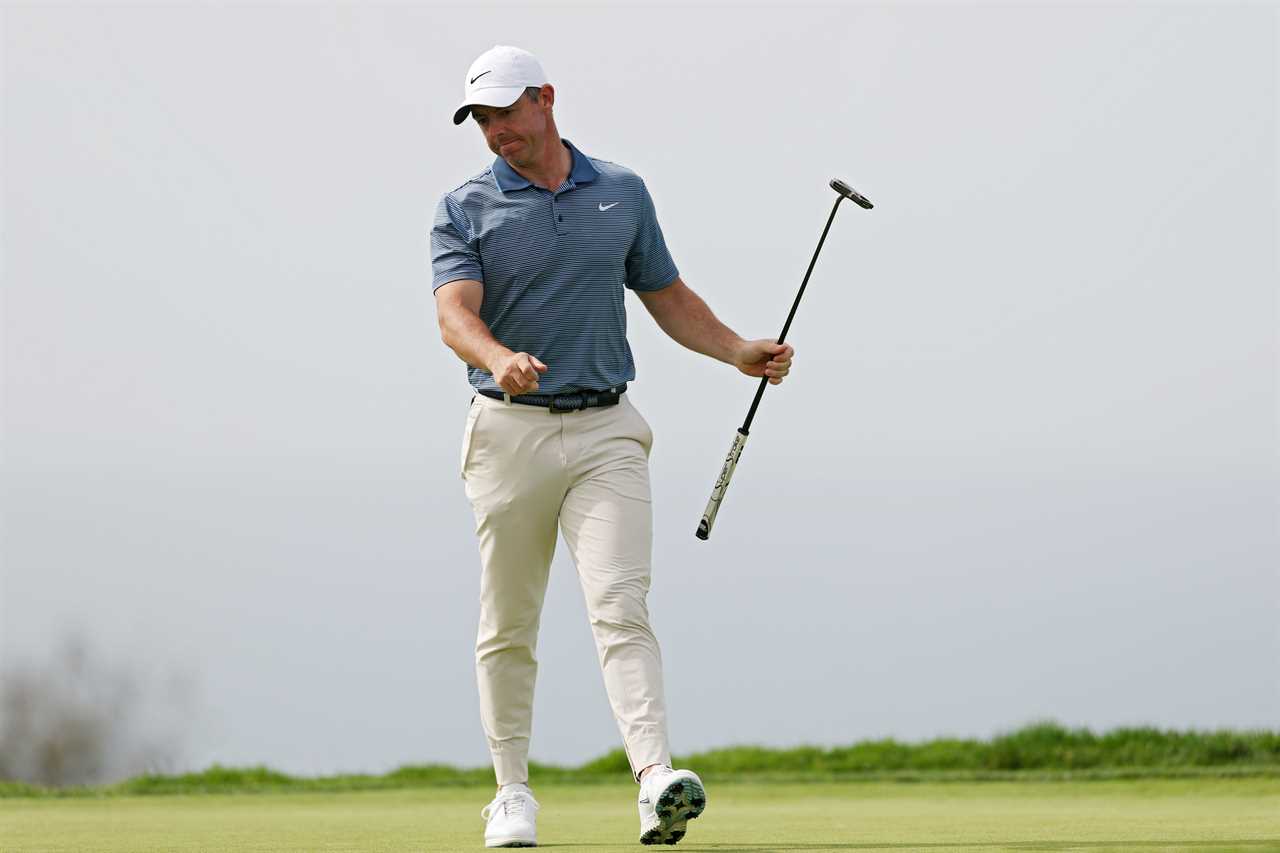 Rory McIlroy walking on a golf course after making par.