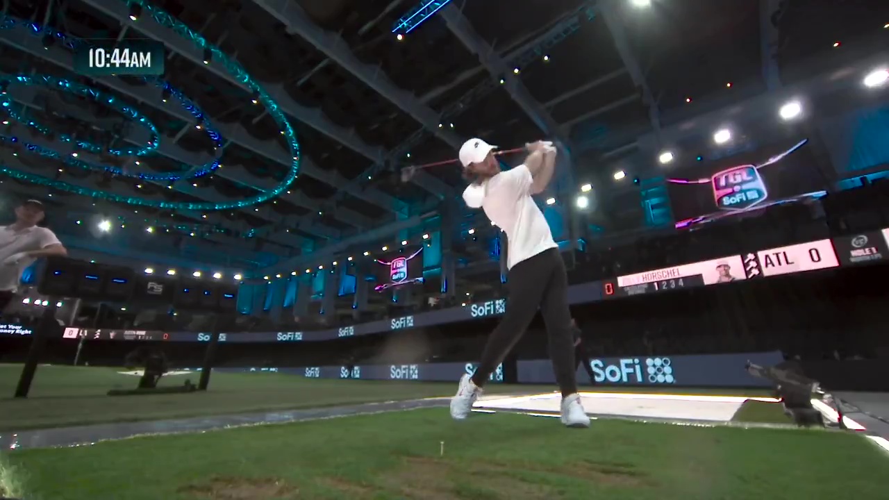 Tommy Fleetwood hitting a golf ball in a golf simulator.