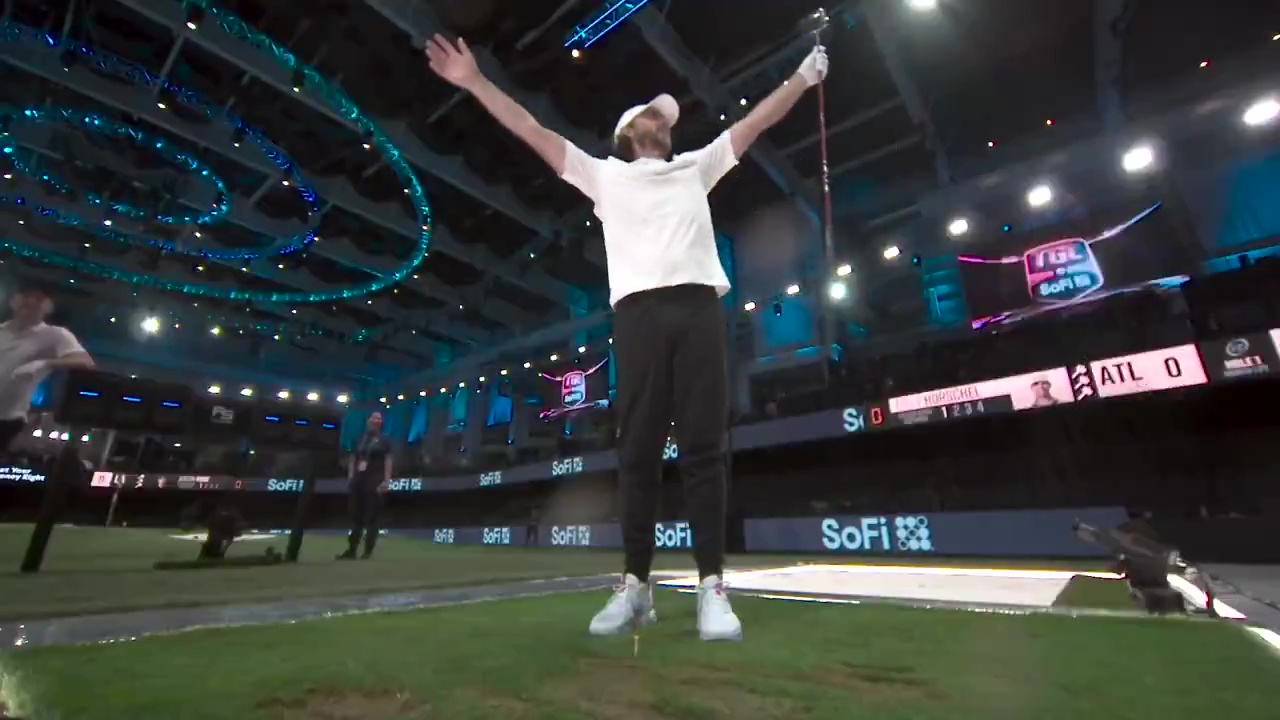 Tommy Fleetwood celebrating a hole-in-one on a golf simulator.