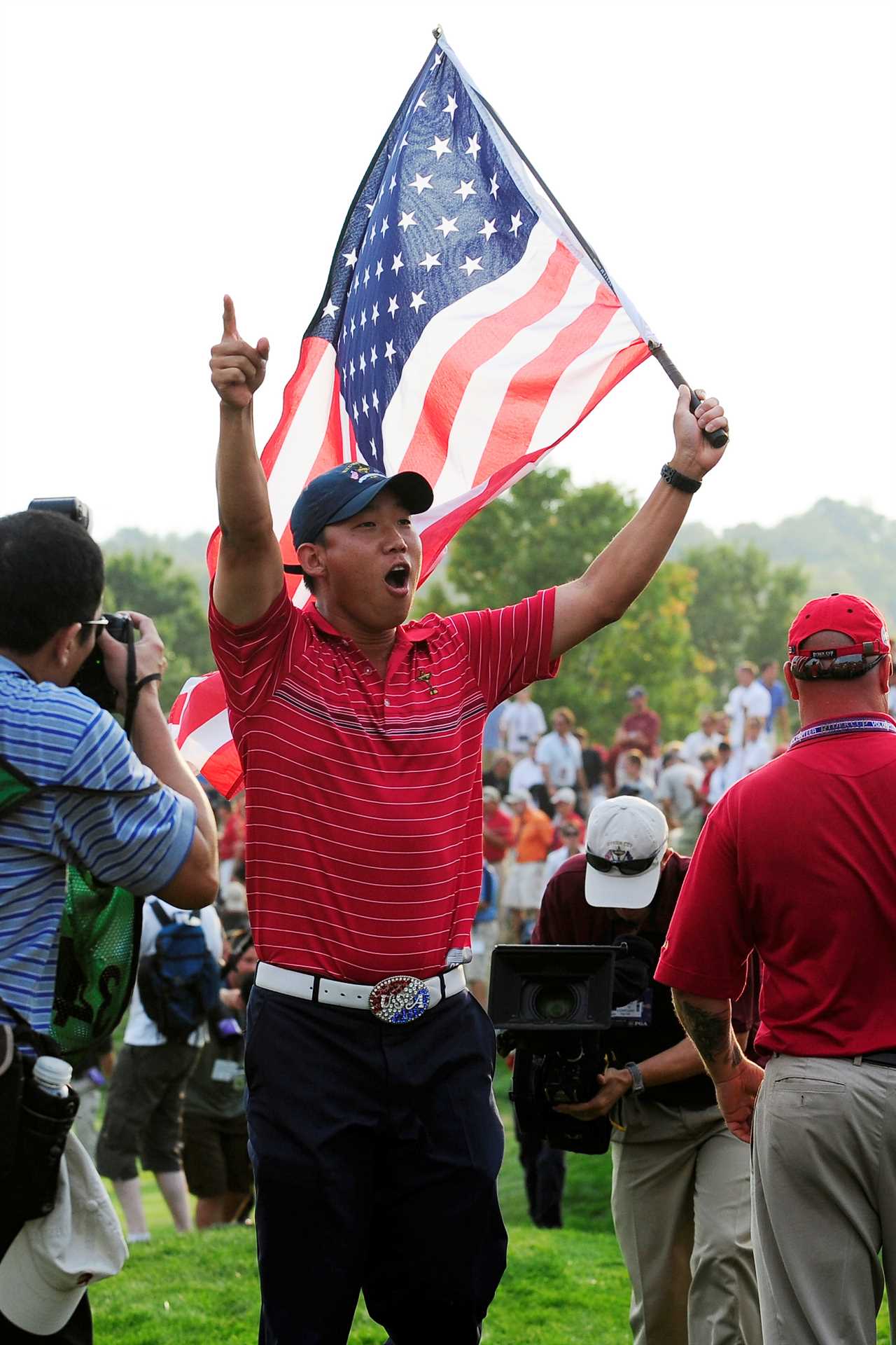 Anthony Kim holding an American flag after a Ryder Cup golf match.