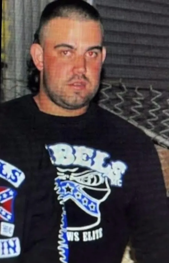 Photo of a man wearing a black long-sleeve shirt with a blue and white design.