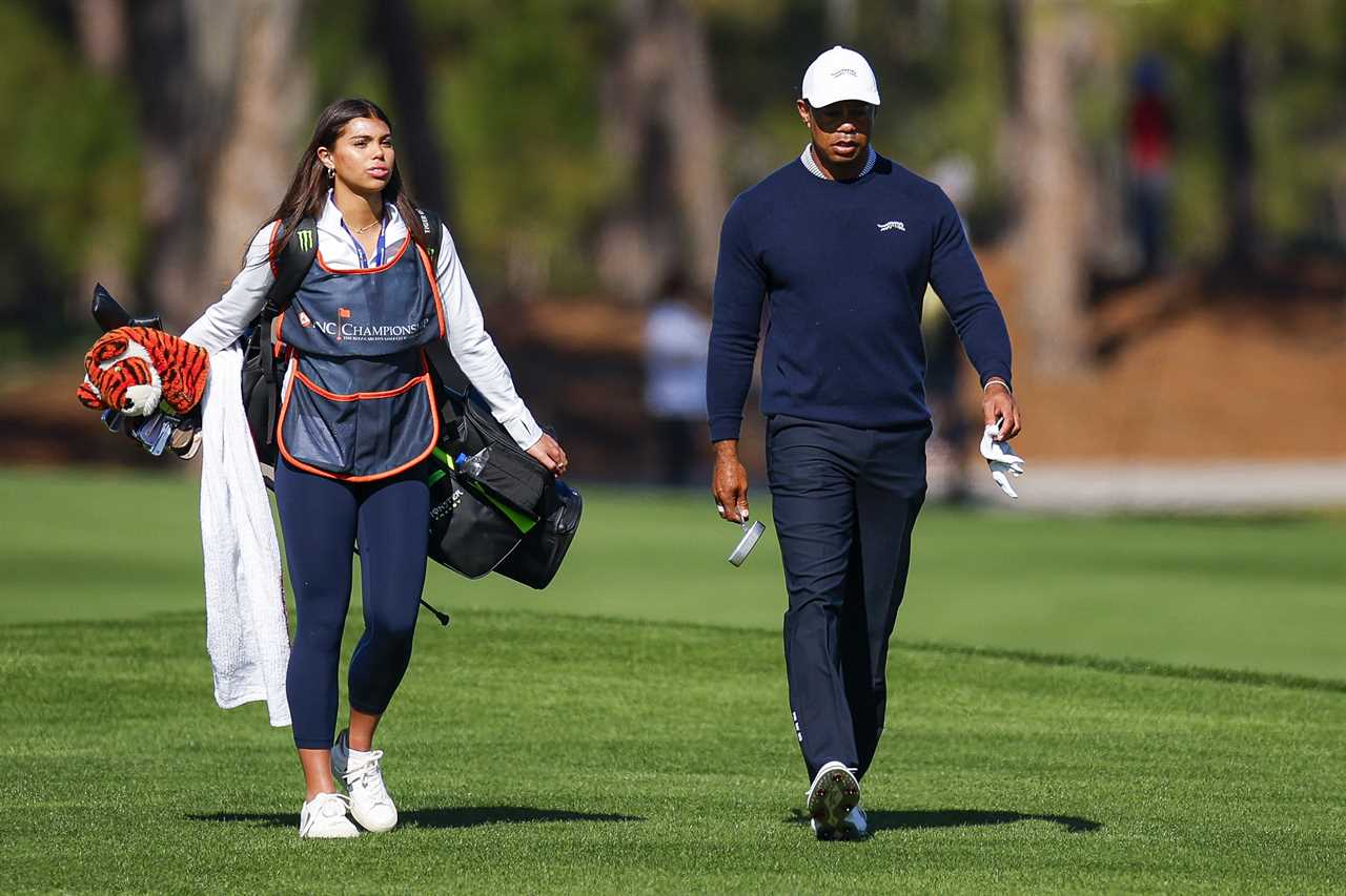 Tiger Woods and his daughter Sam Woods walking on a golf course.