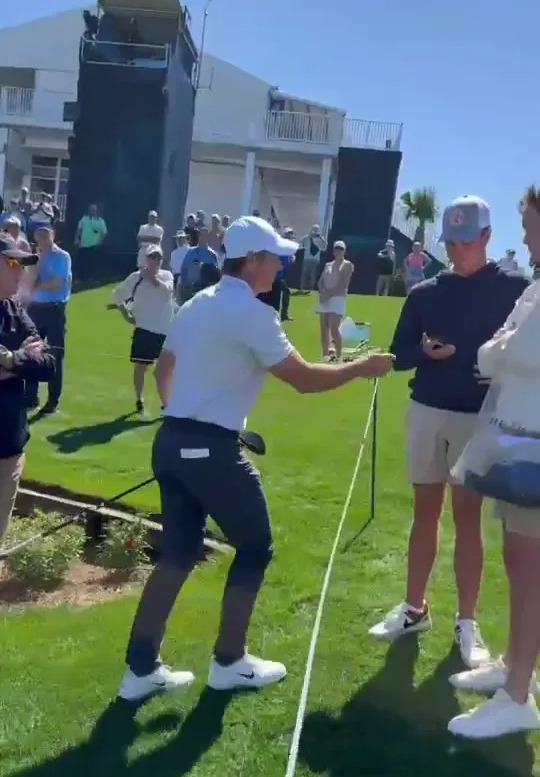 Rory McIlroy taking a fan's phone.