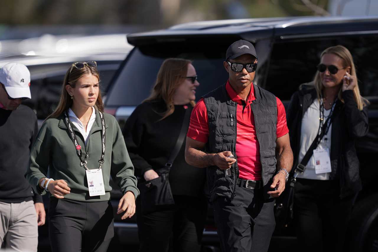 Tiger Woods and Kai Trump walking near cars.