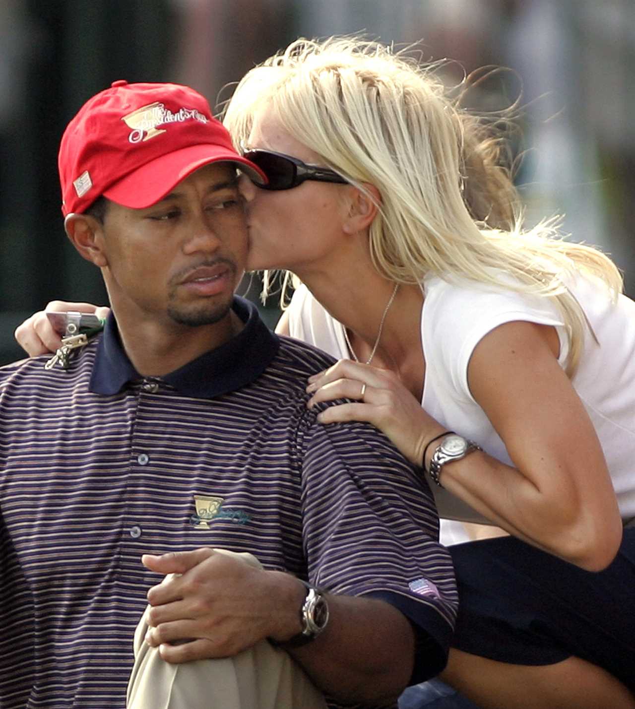 Tiger Woods being kissed on the cheek by his wife, Elin Nordegren.