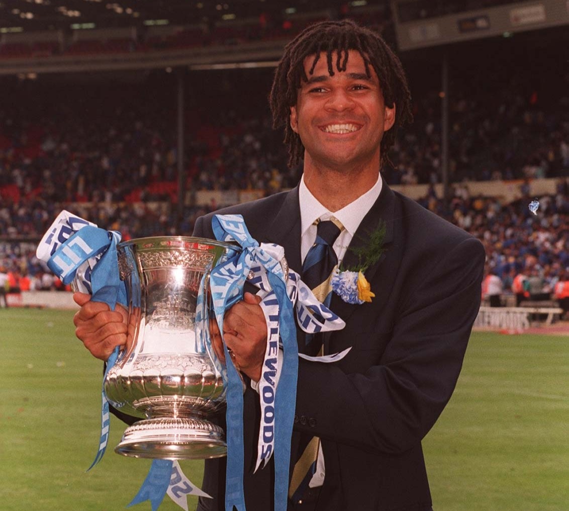 Ruud Gullit holding the FA Cup trophy after Chelsea's victory.