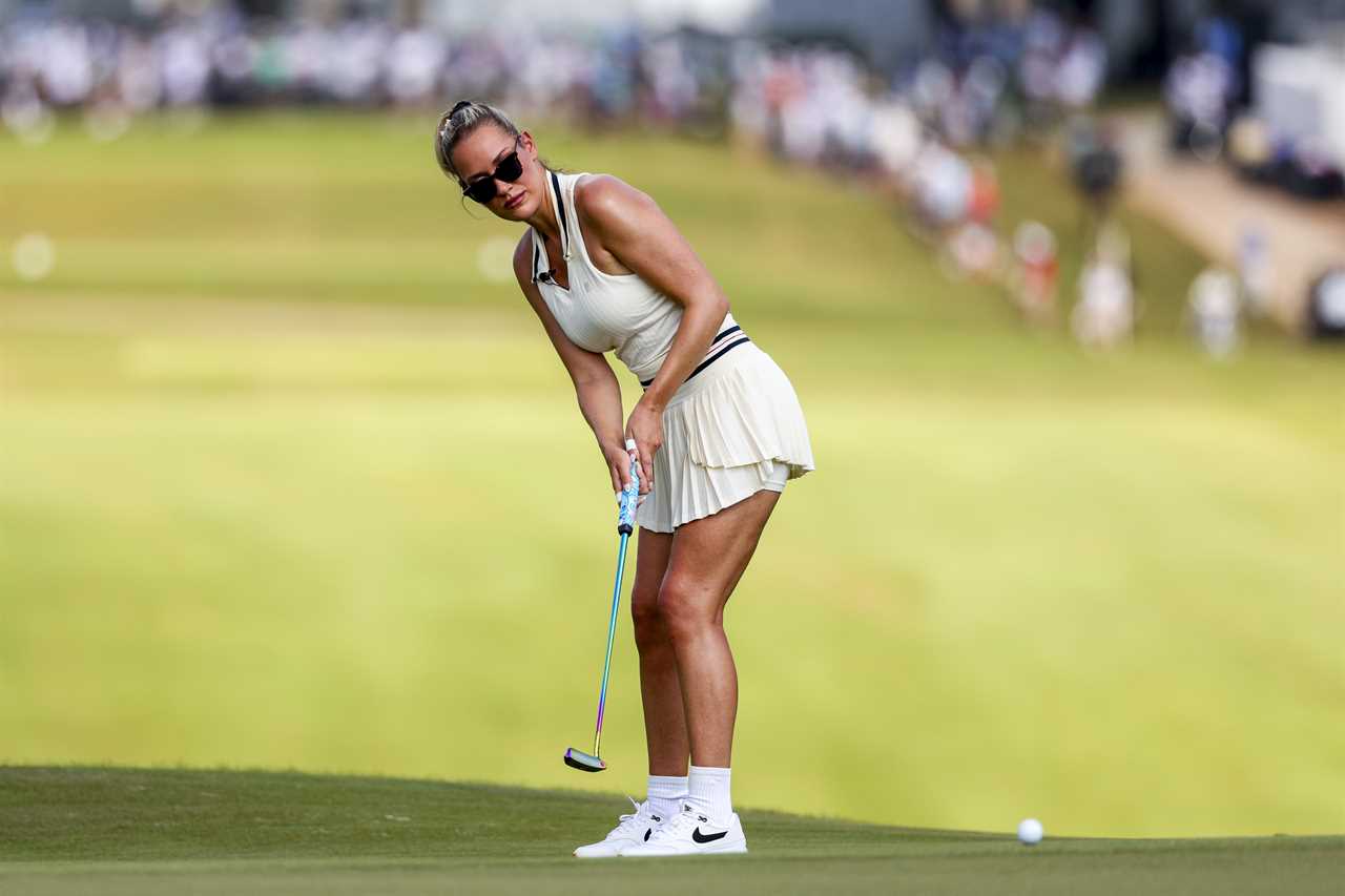 Paige Spiranac watches a putt on a golf course.