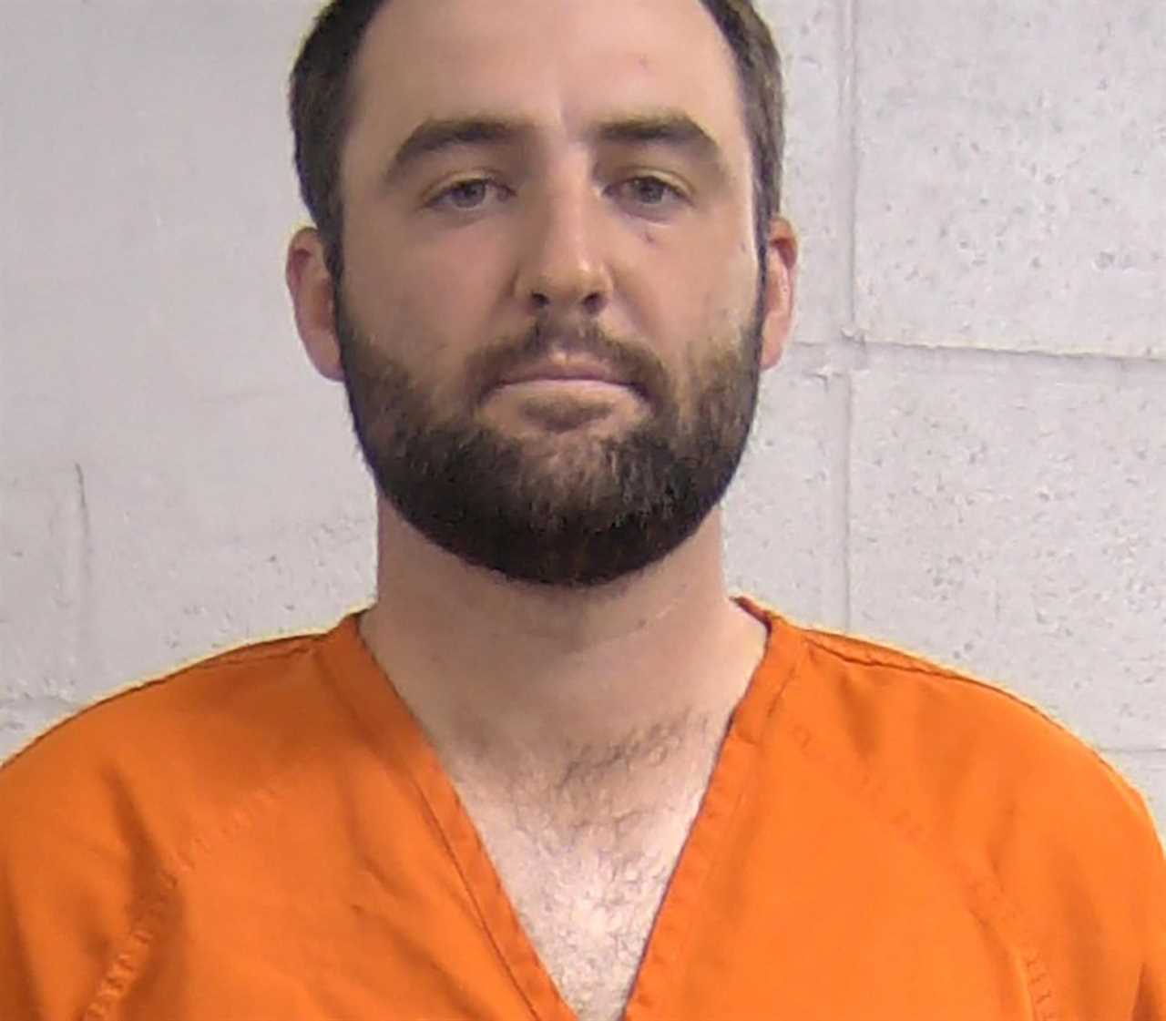 Mugshot of Scottie Scheffler in an orange jumpsuit.