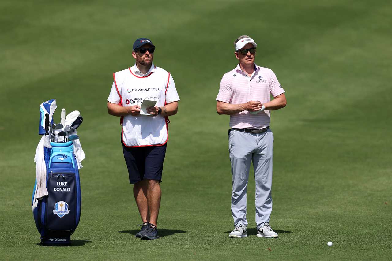Luke Donald and his caddie on a golf course.