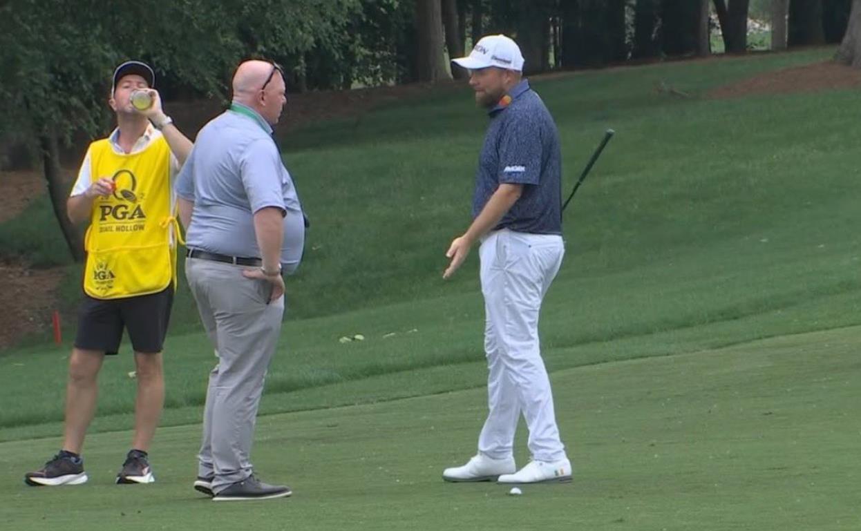 Golfer speaking with two men on a golf course.