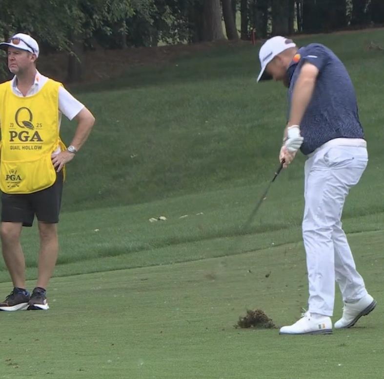 Golfer taking a shot on a golf course.
