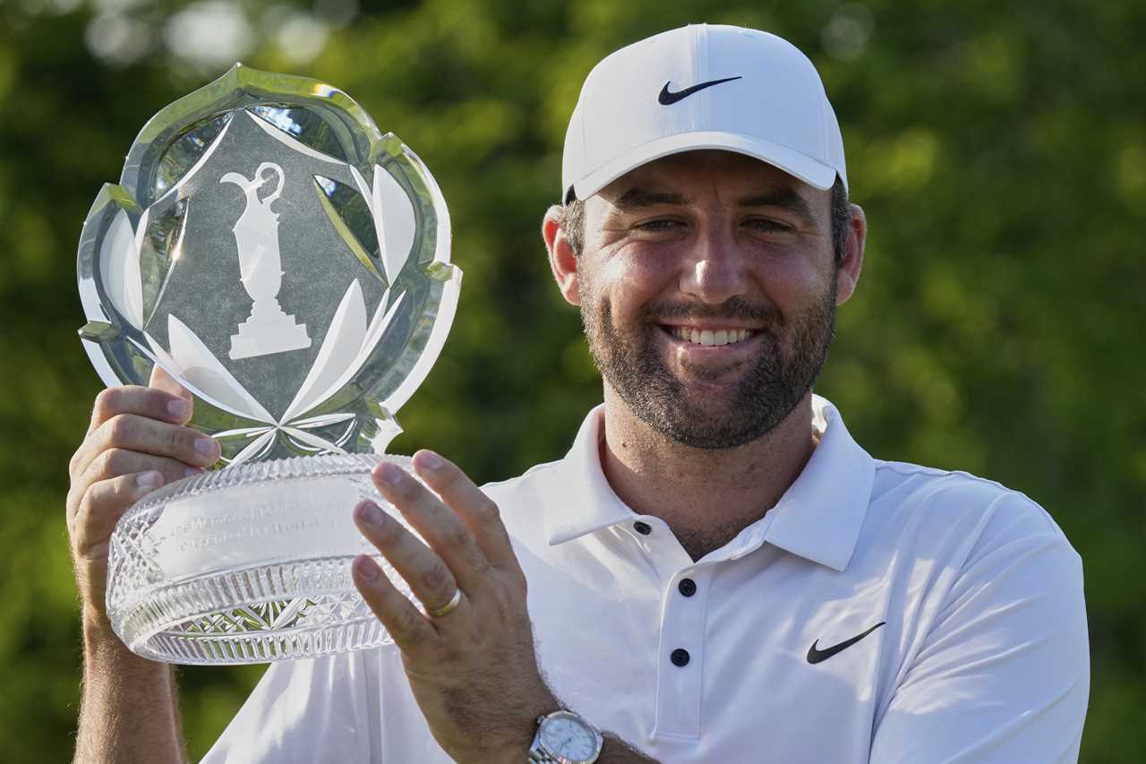Scottie Scheffler holding the Memorial Tournament trophy.
