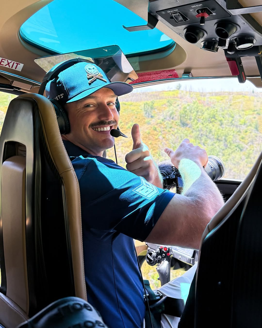 Bryson DeChambeau giving a thumbs-up from inside a helicopter.